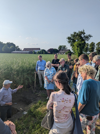 Landwirt Franz-Josef Lintel-Höping zeigt Mitgliedern des Rundes Tisches Biodiversität, des KlimaPaktes Kreis Coesfeld und des Landwirtschaftlichen Kreisverbands Coesfeld anhand eines Bodenprofils den Erfolg seiner Arbeit (Bildquelle: Kreis Coesfeld/Kira Funcke).