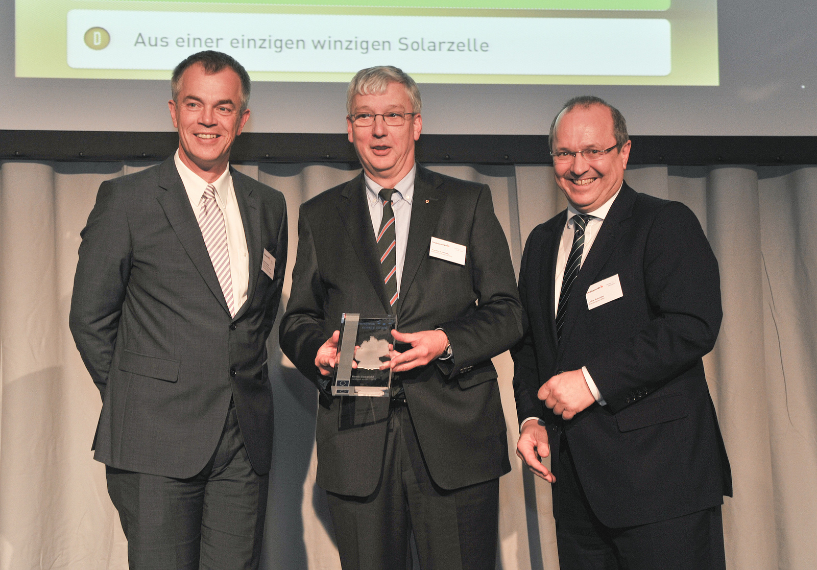 Minister Johannes Remmel (links), der Geschäftsführer der EnergieAgentur.NRW, Lothar Schneider (rechts), übergeben den „European Energy Award“ an Kreisdirektor Joachim L. Gilbeau.